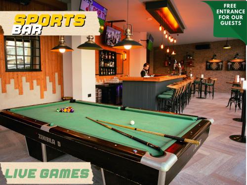 a pool table in a bar with cues on it at Garden View Two Bedroom Apartment in Caesar Resort & SPA, Long Beach in Perivolia tou Trikomou