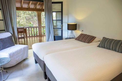 een slaapkamer met 2 bedden en een stoel en een balkon bij Villa Margarita in Palma de Mallorca