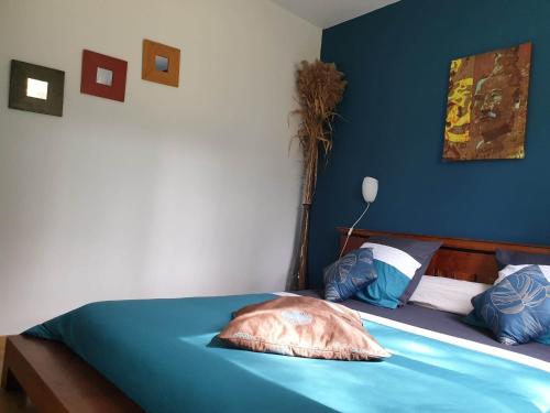 a blue bedroom with a bed with a pillow on it at Autour du Hamac chambres et table d'hôtes in Moltifao