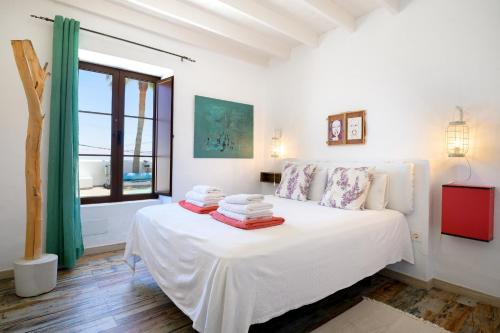 a white bedroom with a bed with towels on it at Casa El Patio Teseguite in Teseguite