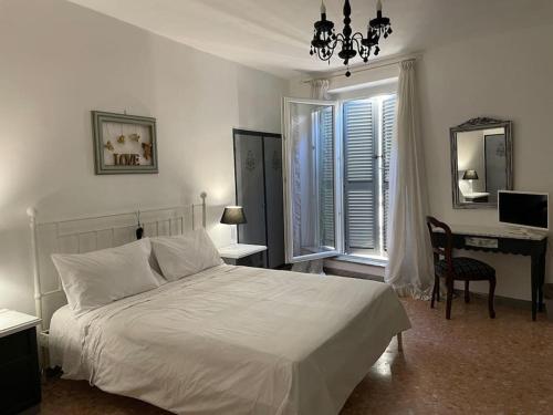 a bedroom with a white bed and a desk with a computer at appartamento velletri centro in Velletri