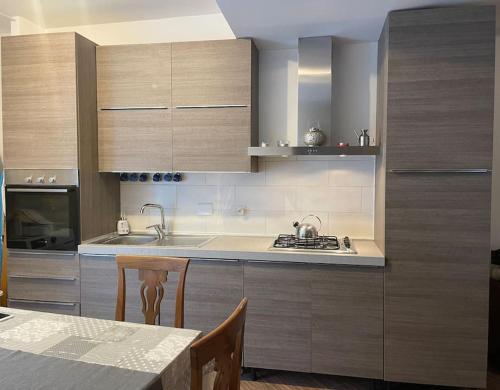 een keuken met houten kasten en een tafel met een tafel sidx sidx bij appartamento velletri centro in Velletri