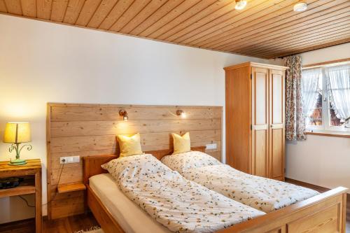 um quarto com uma cama e uma cabeceira em madeira em Ferienwohnung Lengdobler - Leni em Bad Kohlgrub