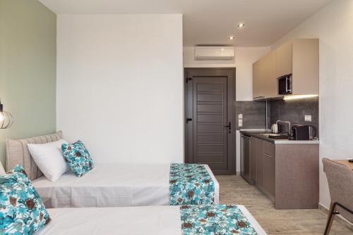 a hotel room with two beds and a kitchen at THEA Luxury Apartments in Vourvourou