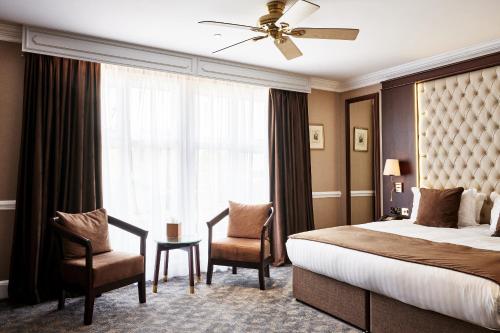 a hotel room with a bed and a window at Warren House Hotel in Kingston upon Thames