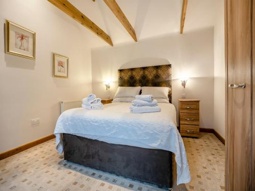 a bedroom with a large bed with towels on it at The Lodge - Uk44516 in North Thoresby