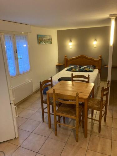- une chambre avec un lit, une table en bois et des chaises dans l'établissement Studio Marseillan plage Robinson, à Le Castellas