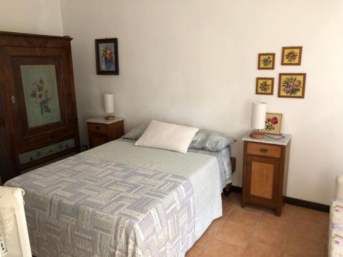 ein Schlafzimmer mit einem Bett und zwei Nachttischen und zwei Lampen in der Unterkunft La casa nel bosco in Gorizia