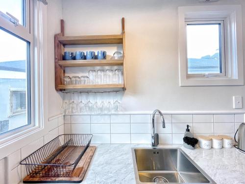 une cuisine avec un évier et une fenêtre dans l'établissement Cozy n Comfortable,5 mins to airport, à Wellington