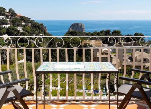 a table on a balcony with a view of the ocean at Sina Flora in Capri