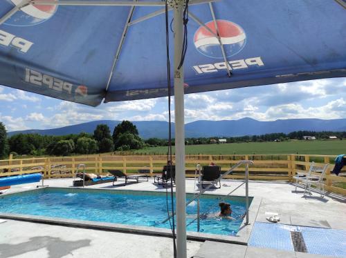 a person in a swimming pool under an umbrella at Willa Kolorowa Chata 6 km Od Karpacza in Mysłakowice