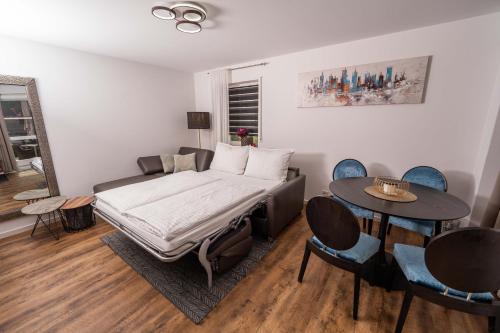 un letto in una camera con tavolo e sedie di CityWohnungFN a Friedrichshafen