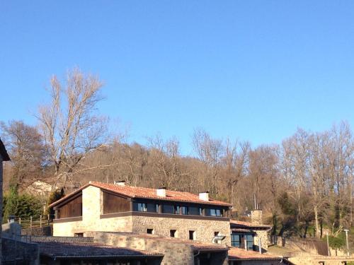 a large brick house in front of a mountain at Hotel Boutique Puig Francó - Adults Only in Camprodon
