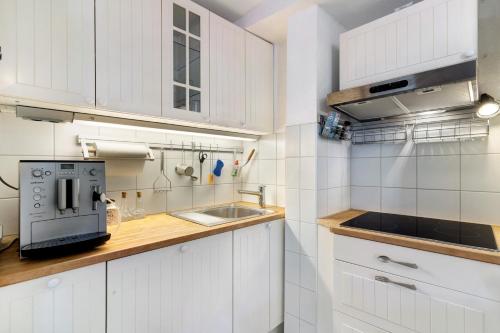cocina blanca con fregadero y microondas en Casa Stadtblick, en Gengenbach