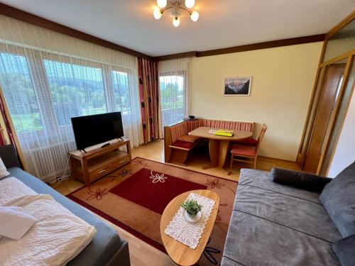 a living room with a couch and a table at Gästehaus Wallner in Presseggen