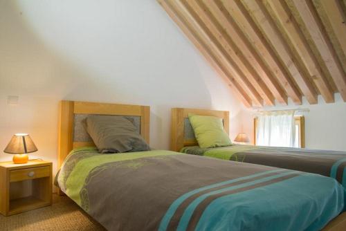 1 dormitorio con 2 camas y mesa con lámpara en Mas de la Barque, en Gourdouze