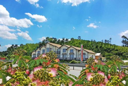 a row of houses on the side of a road with flowers at Amigas Ocean View Pension in Yangyang