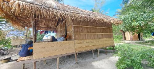 a hut with two people sitting in it at Raja Ampat Jousuba Homestay in Minyaifuin