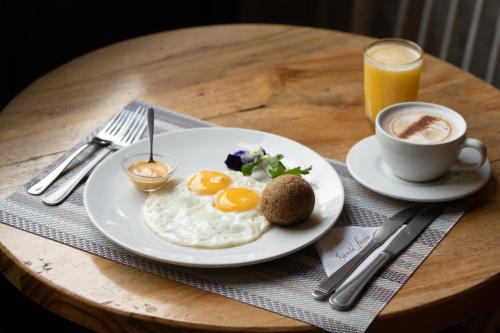 a plate of eggs and a cup of coffee on a table at Hotel Boutique Santa Lucia in Cuenca