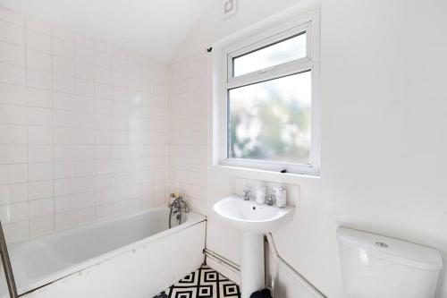 吉林漢姆的住宿－Reve Bleu，白色的浴室设有水槽、浴缸和窗户。