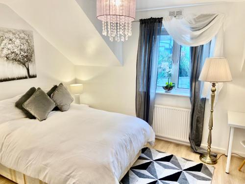 1 dormitorio con cama blanca y ventana en London Studio Self Contained, Newly Furbished en Londres