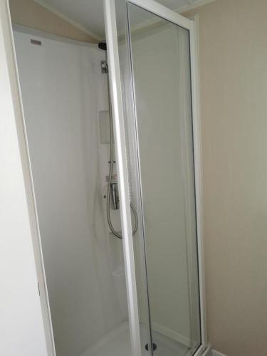 a shower with a glass door in a bathroom at The mistral golden gate towyn in Kinmel Bay