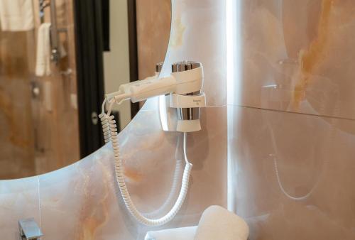 a phone hanging on a wall next to a mirror at 4heavens_naples in Naples