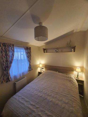 a bedroom with a large bed and a window at The mistral golden gate towyn in Kinmel Bay