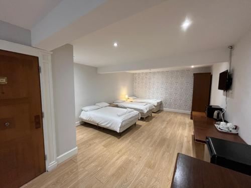 a hotel room with two beds and a television at Park View Rooms in Edinburgh