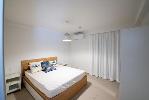 ein weißes Schlafzimmer mit einem Bett und einem Fenster in der Unterkunft Ennea suites- Dark suite in Flámbouras