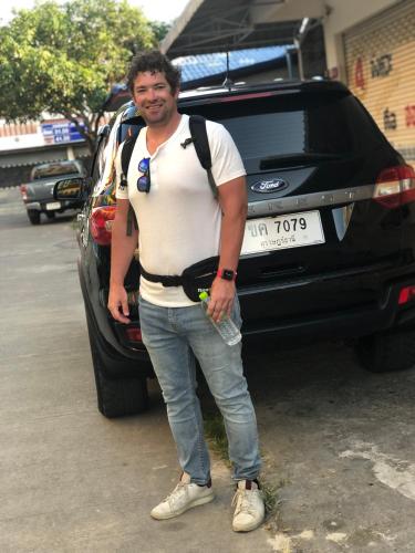 a man is standing in front of a car at Baansrisuthum in Don Sak