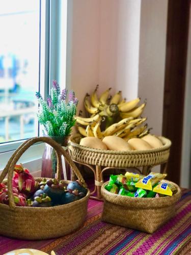 two baskets of fruit and vegetables on a table at Baansrisuthum in Don Sak