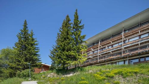 a building with two trees in front of it at V du Bachat Arolles A12 - Appt 6 pers in Chamrousse