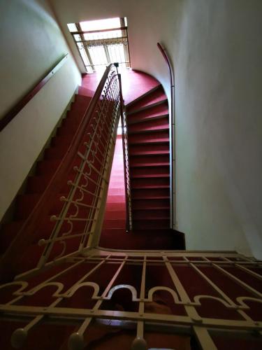 a spiral staircase in an old building with pink lighting at Herrnhof in Reichenau