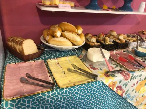 una mesa con pan y otros alimentos. en Pousada Chuá Chuá en Conservatória