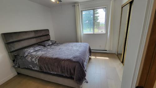 Un dormitorio con una cama grande y una ventana en Vacation House central location from anywhere in Montreal, en Laval
