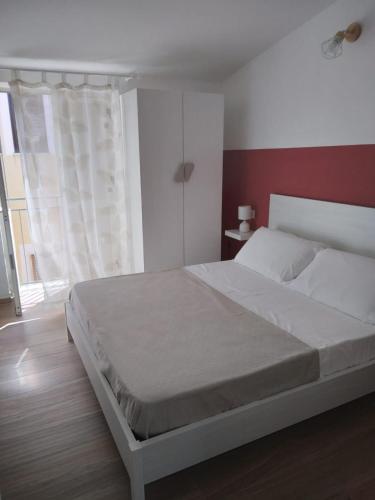 a bedroom with a white bed and a window at Casa sulla Punta in Marina di Camerota