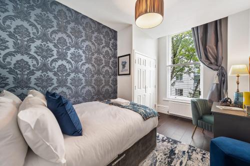 een slaapkamer met een bed en een muur met een raam bij Host & Stay - Princes Park Abode in Liverpool