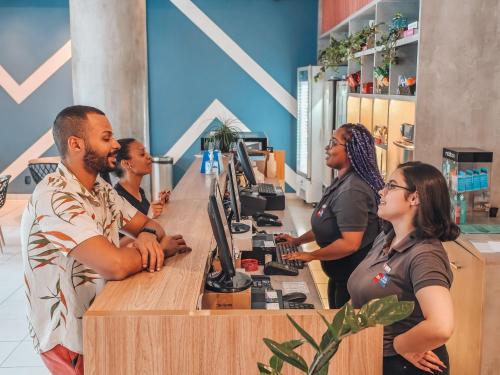 a group of people standing around a counter with computers at ibis budget Rio de Janeiro Centro in Rio de Janeiro