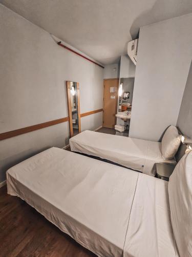 a hospital room with two beds and a mirror at ibis budget Rio de Janeiro Centro in Rio de Janeiro