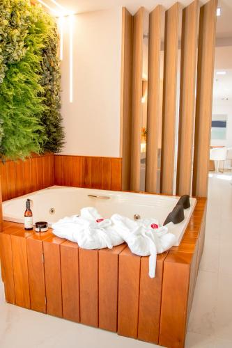 a jacuzzi tub in a hotel room with towels at Ramada Hotel & Suites Campos Pelinca in Campos dos Goytacazes
