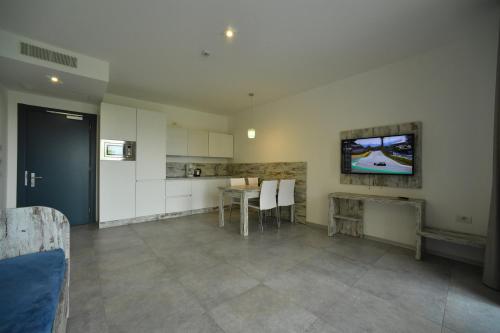 a kitchen with a table and a tv on the wall at Residence Malcesine-Active&Family in Malcesine