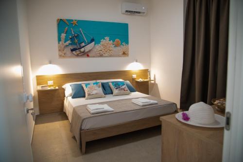 a bedroom with a bed and a painting on the wall at Granelli di sabbia in Porto Cesareo