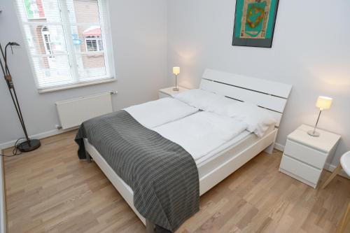 a bedroom with a bed and two lamps in it at Sønderborg City Apartments in Sønderborg