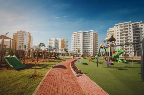a playground with a slide and swings at Garden View Two Bedroom Apartment in Caesar Resort & SPA, Long Beach in Perivolia tou Trikomou