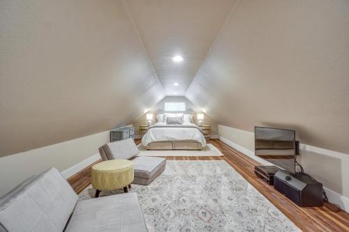 a attic bedroom with a bed and a tv at Old Town Carriage House with Private Patio in Fort Collins