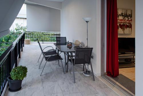 a patio with a table and chairs on a balcony at Homey Comfort Apartments in Athens