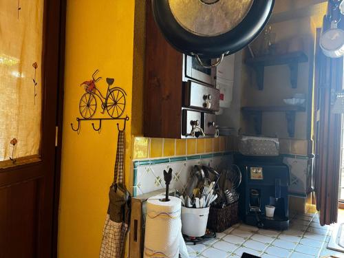 a kitchen with a yellow wall with a bike on the wall at La Maggiorana in Tagliacozzo