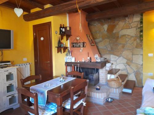 salon ze stołem i kamiennym kominkiem w obiekcie La Maggiorana w mieście Tagliacozzo