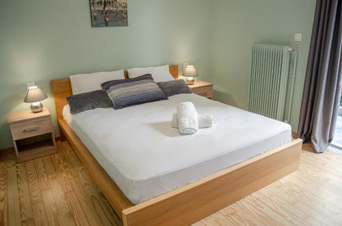 - une chambre dotée d'un grand lit avec des draps et des oreillers blancs dans l'établissement Homey Comfort Apartments, à Athènes